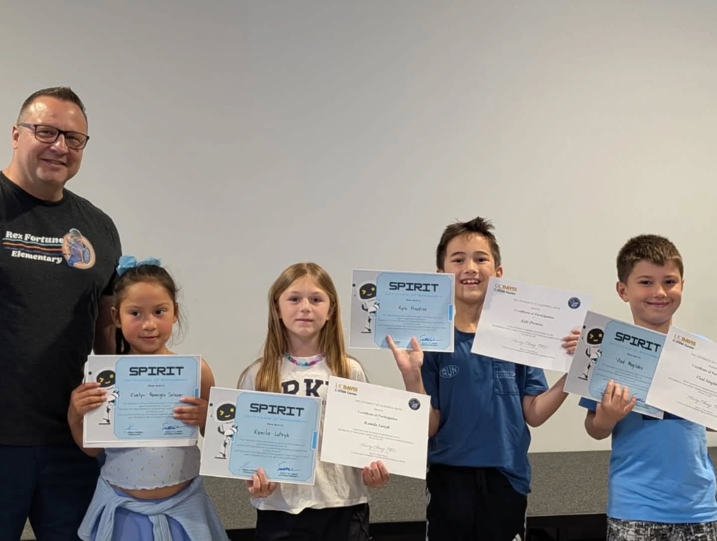 students hold up awards