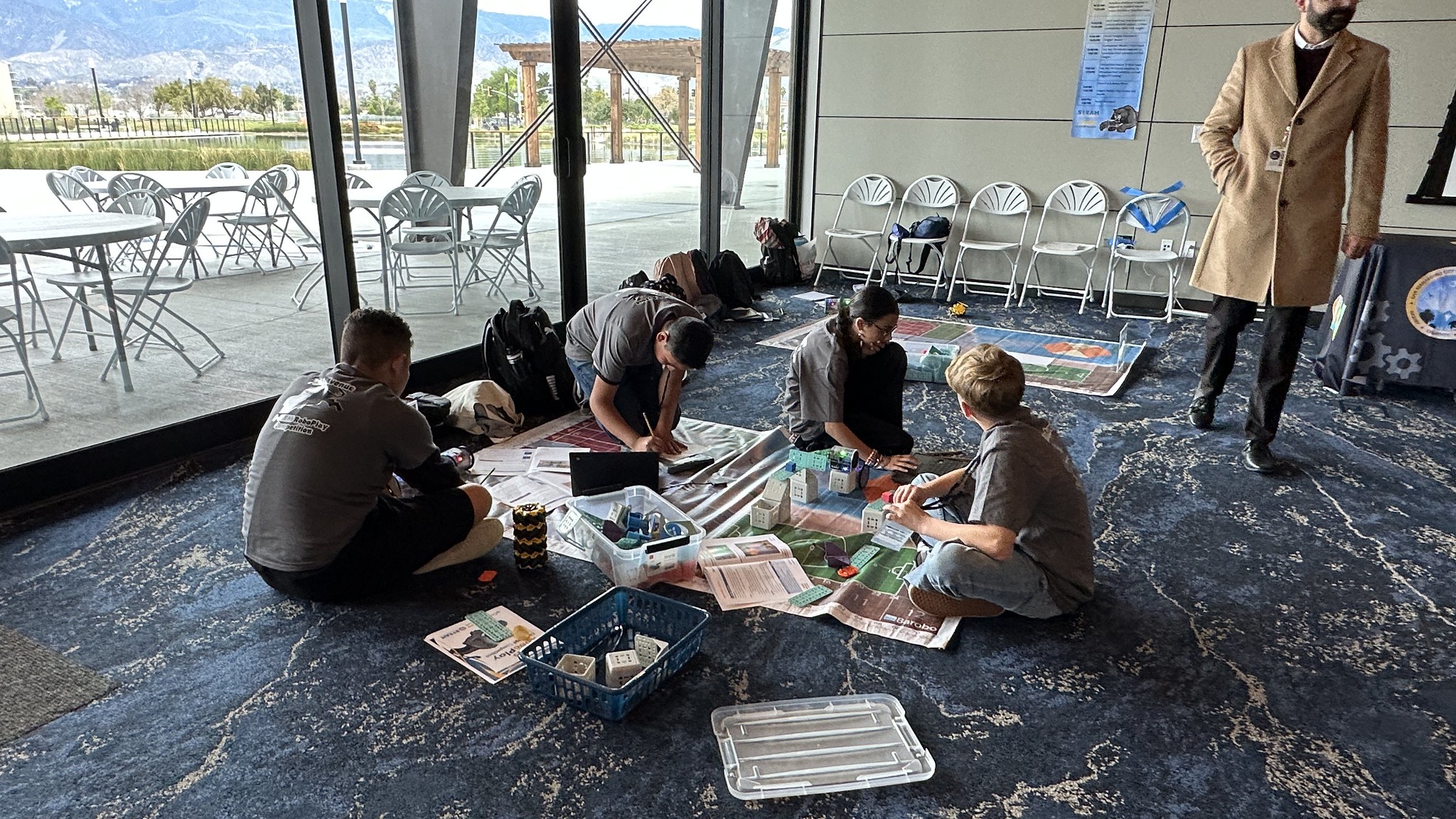 students gather on the floor to build their robots