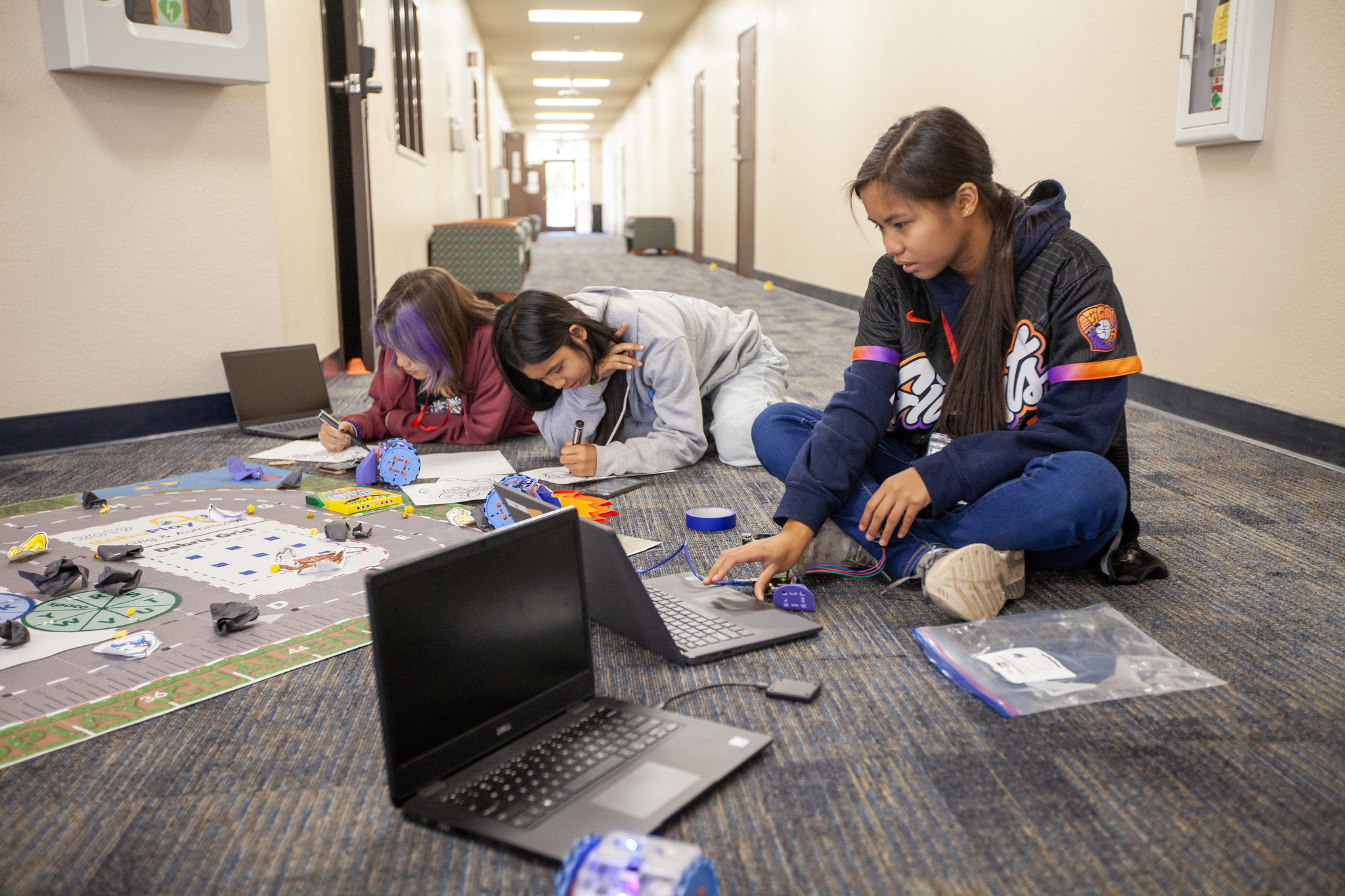 2 students programming their linkbot on the floor