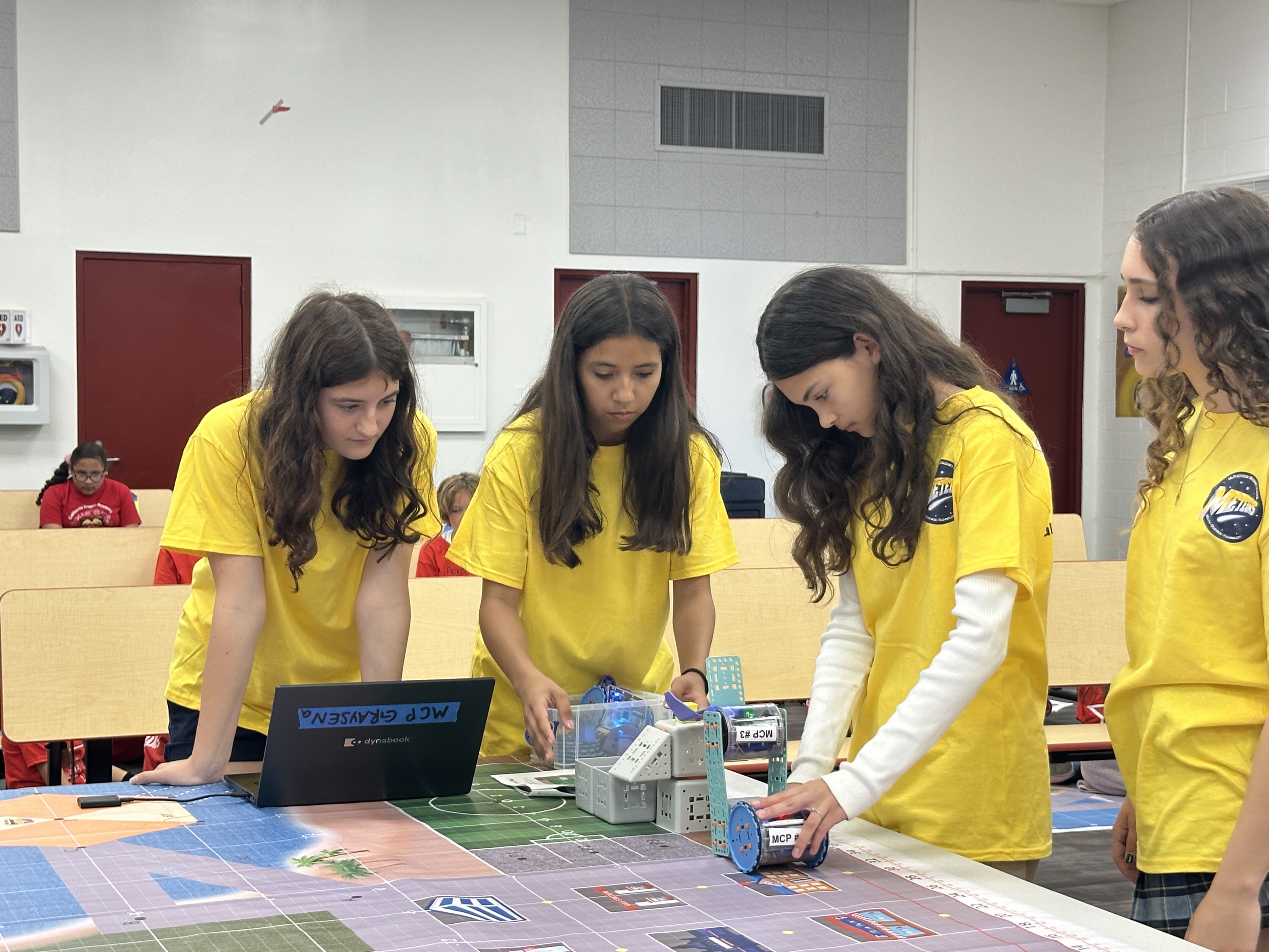 4 students coding a robot