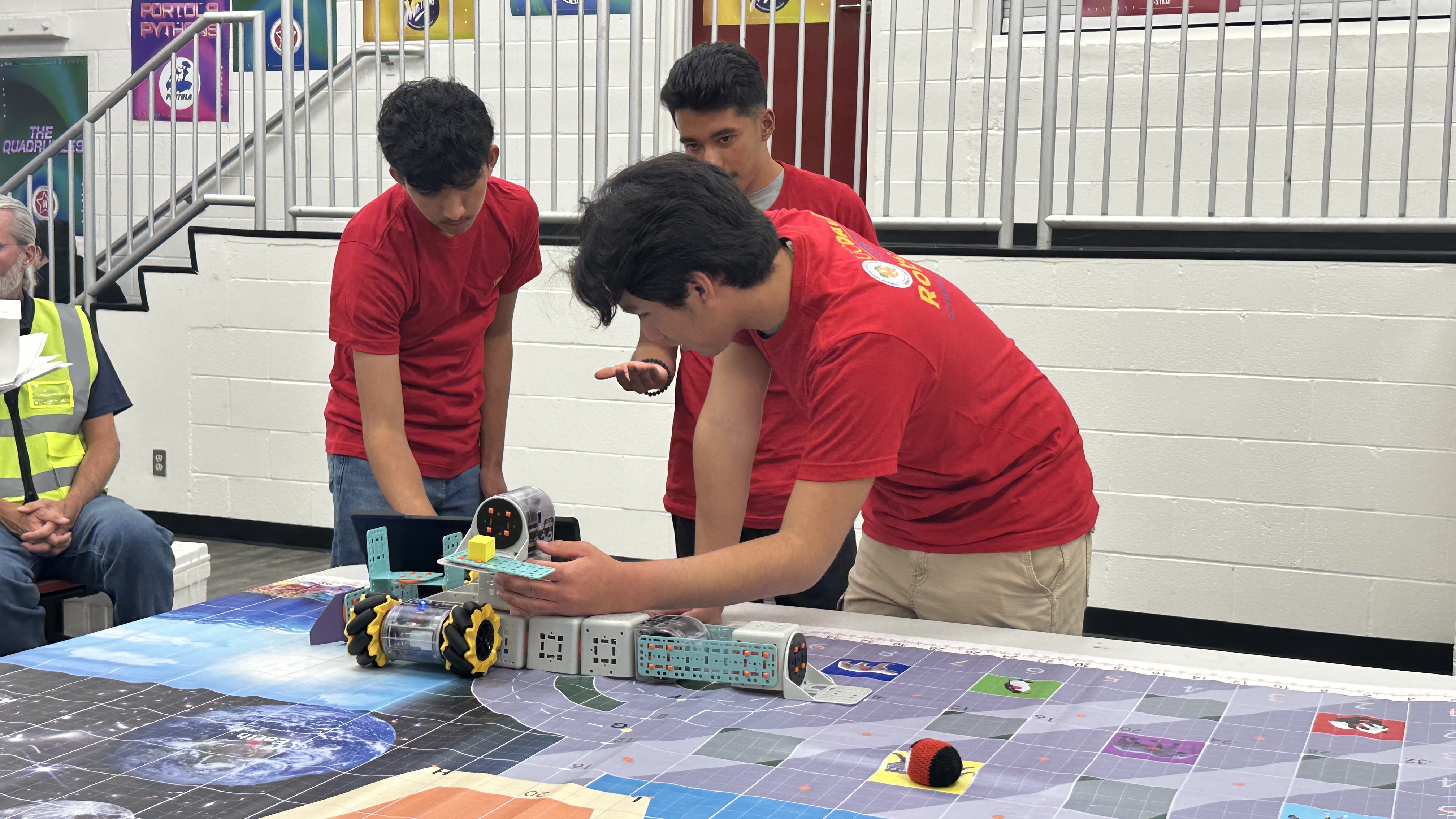 3 students coding a robot