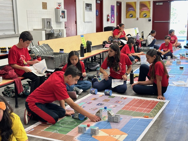 students sitting on the floor programming Linkbot robots