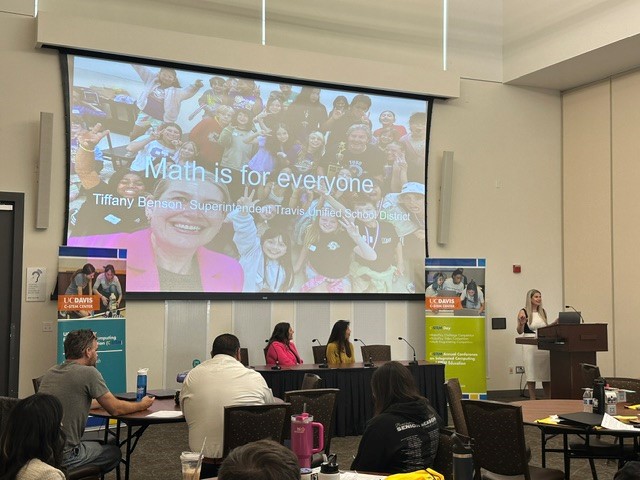 Classroom with students and instructor; projected photo collage reading "Math is for everyone."