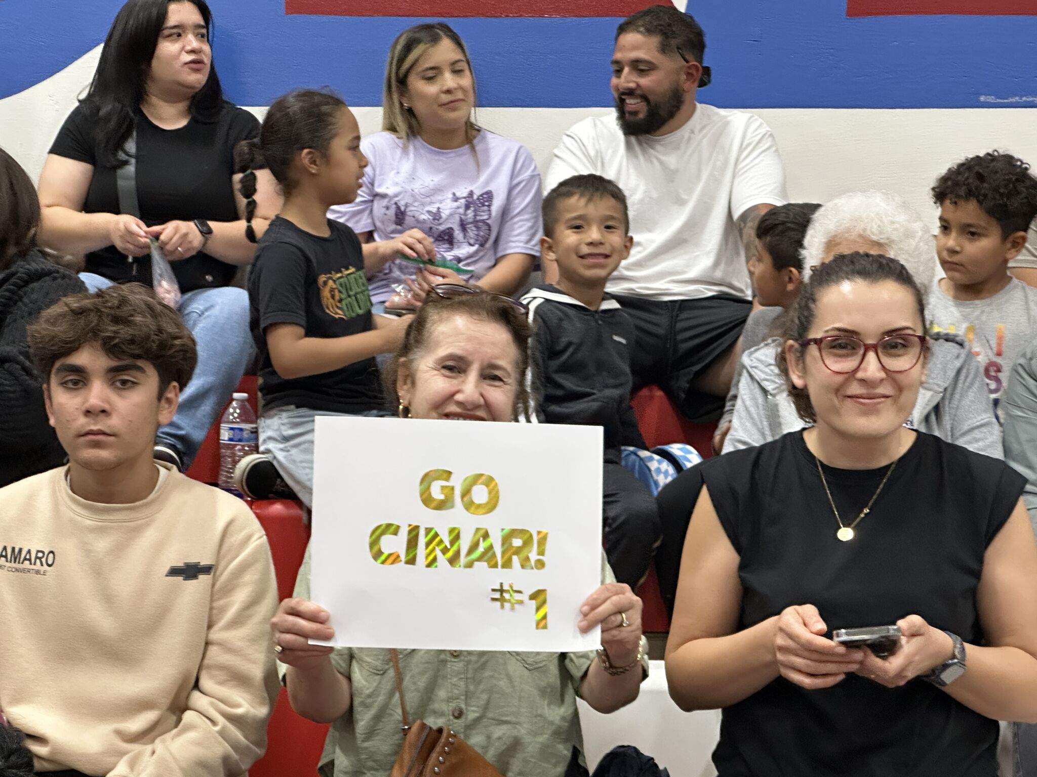family holding a sign and cheering on their student