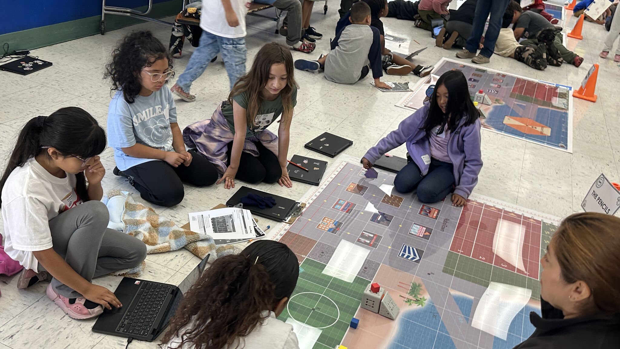 group of students sitting and programming a robot