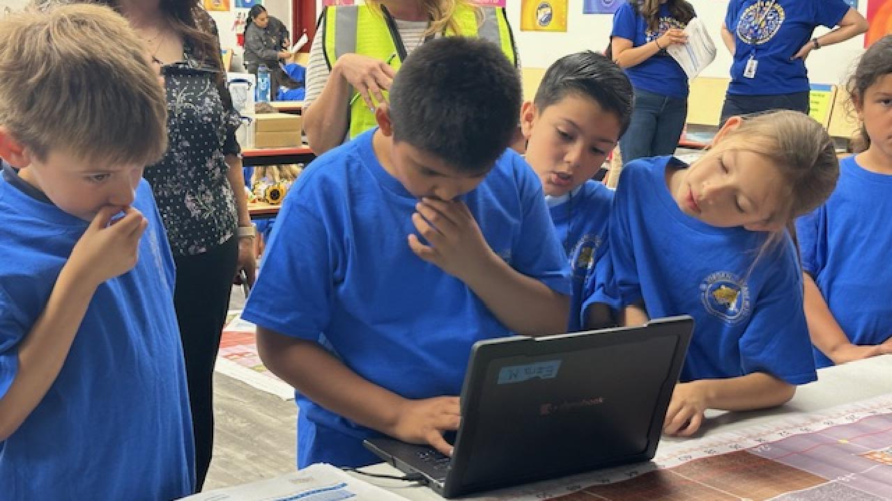 students programming on a laptop