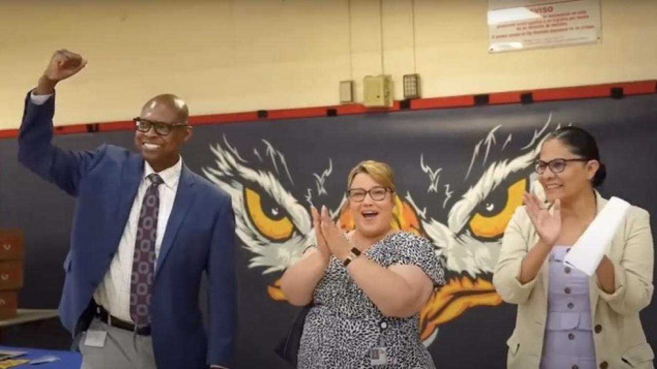 man and 2 woman pumping fists in the air and clapping